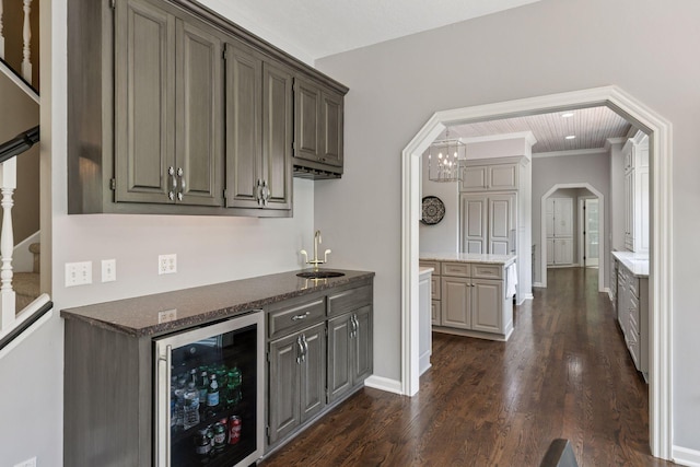 9320 Abigail Ct, Inver Grove Heights, MN 55077 - indoor bar featuring beverage cooler, dark wood-type flooring, arched walkways, baseboards, and stairway