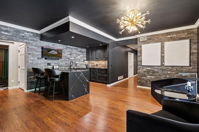 9320 Abigail Ct, Inver Grove Heights, MN 55077 - bar with a chandelier, wood finished floors, ornamental molding, baseboards, and backsplash