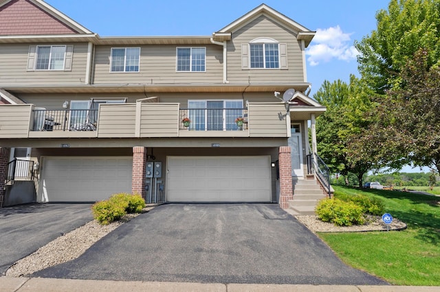 14085 Wilds Path NW, Prior Lake, MN 55372 - view of property featuring asphalt driveway, a garage, brick siding, and a balcony