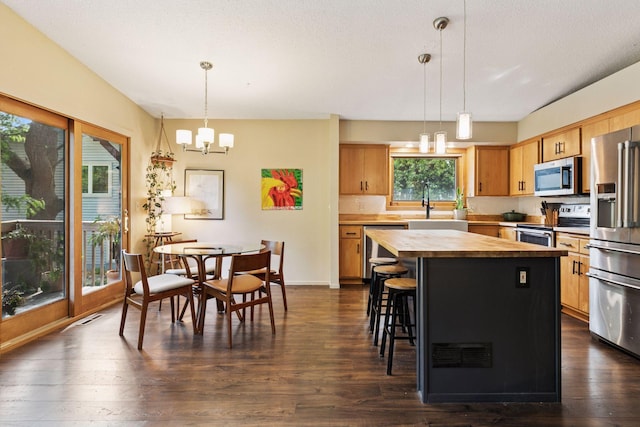 164 Wendy Ct, Shoreview, MN 55126 - kitchen with stainless steel appliances, wood counters, dark wood finished floors, a center island, and a chandelier
