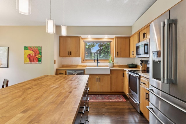 164 Wendy Ct, Shoreview, MN 55126 - kitchen featuring stainless steel appliances, wood counters, a sink, dark wood-type flooring, and pendant lighting