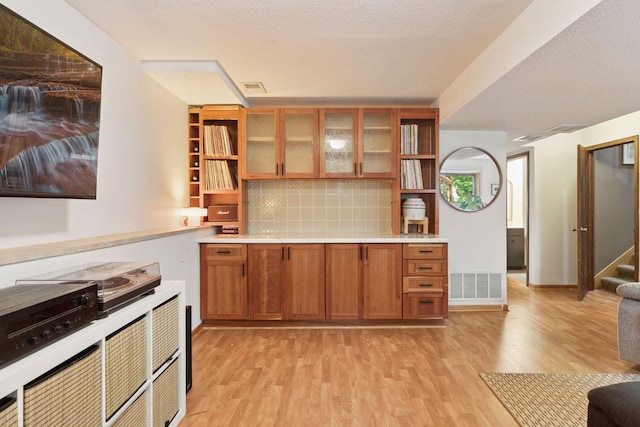 164 Wendy Ct, Shoreview, MN 55126 - kitchen with open shelves, light wood-style flooring, brown cabinetry, tasteful backsplash, and light countertops