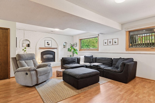 164 Wendy Ct, Shoreview, MN 55126 - living area featuring light wood-style flooring, a textured ceiling, baseboards, and a brick fireplace