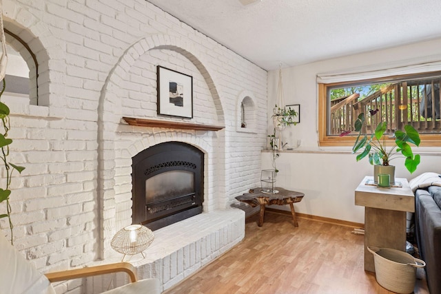 164 Wendy Ct, Shoreview, MN 55126 - living room with baseboards, wood finished floors, a brick fireplace, and a textured ceiling