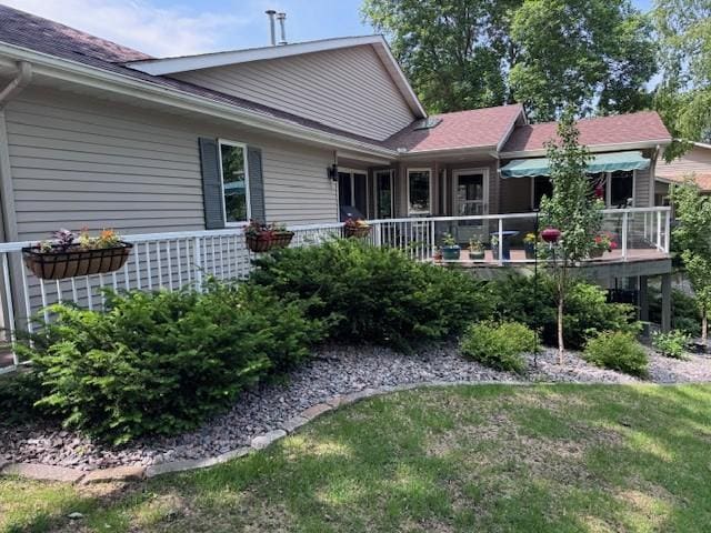 706 Pershing Ave N, New Prague, MN 56071 - rear view of property featuring a deck, a shingled roof, and a lawn
