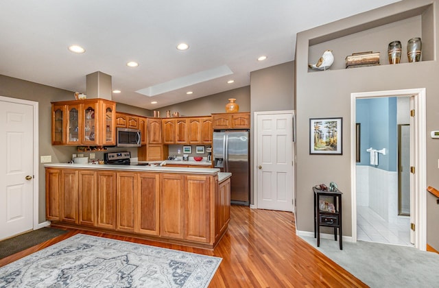 706 Pershing Ave N, New Prague, MN 56071 - kitchen with a peninsula, appliances with stainless steel finishes, brown cabinetry, recessed lighting, and glass insert cabinets