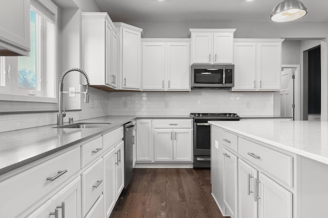 12946 Jewell Cir, Blaine, MN 55449 - kitchen with stainless steel appliances, a sink, white cabinetry, and backsplash
