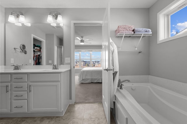 12946 Jewell Cir, Blaine, MN 55449 - full bathroom with a garden tub, double vanity, ensuite bath, ceiling fan, and a walk in closet