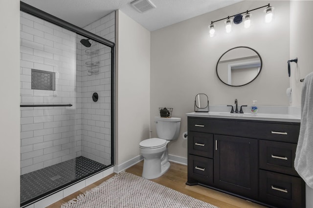 12946 Jewell Cir, Blaine, MN 55449 - bathroom featuring toilet, vanity, a stall shower, wood finished floors, and baseboards