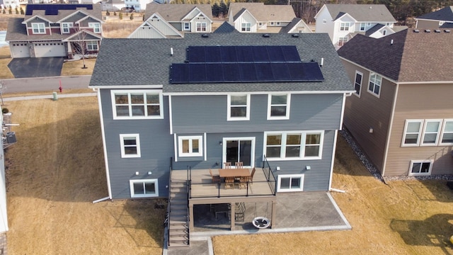 12946 Jewell Cir, Blaine, MN 55449 - back of house featuring a residential view, roof with shingles, and solar panels