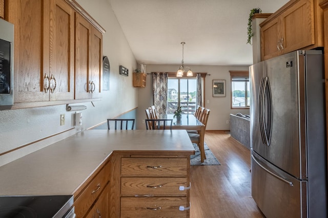 250 18th Ave SE, Saint Joseph, MN 56374 - kitchen featuring freestanding refrigerator, brown cabinets, wood finished floors, and a peninsula