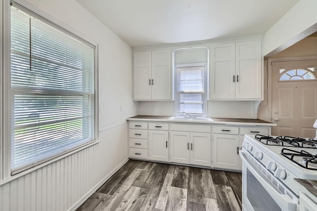 4921 Fremont Ave N, Minneapolis, MN 55430 - kitchen featuring white range with gas cooktop, plenty of natural light, white cabinets, wainscoting, and a sink
