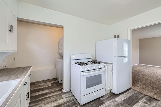 4921 Fremont Ave N, Minneapolis, MN 55430 - kitchen featuring white appliances, stacked washer and clothes dryer, white cabinets, light countertops, and dark wood-style floors
