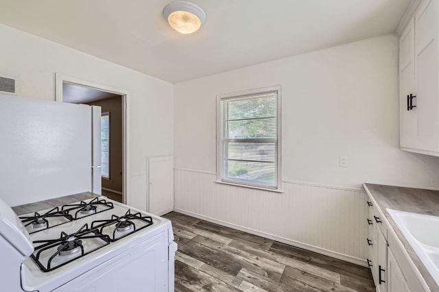 4921 Fremont Ave N, Minneapolis, MN 55430 - kitchen featuring white appliances, a wainscoted wall, wood finished floors, white cabinetry, and a sink