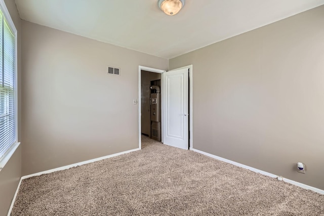 4921 Fremont Ave N, Minneapolis, MN 55430 - carpeted spare room featuring baseboards and water heater