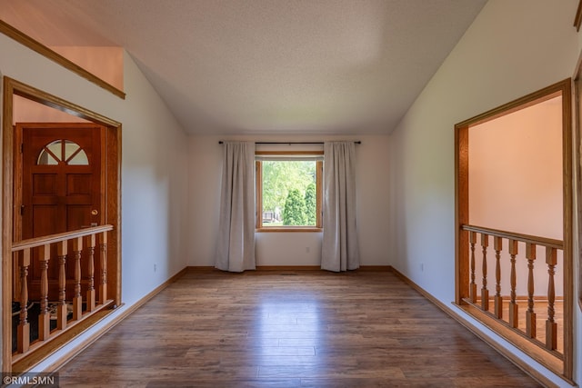 2226 Whispering Trl, Eagan, MN 55122 - empty room with lofted ceiling, wood finished floors, baseboards, and a textured ceiling