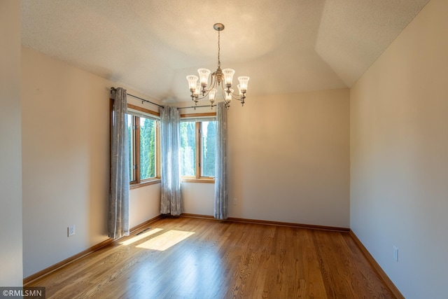 2226 Whispering Trl, Eagan, MN 55122 - spare room featuring a chandelier, wood finished floors, baseboards, and lofted ceiling