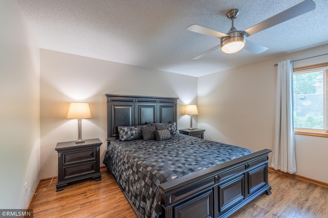 2226 Whispering Trl, Eagan, MN 55122 - bedroom featuring light wood-style flooring, a textured ceiling, a ceiling fan, and baseboards