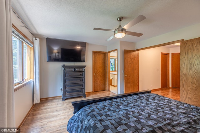 2226 Whispering Trl, Eagan, MN 55122 - bedroom with light wood-type flooring, a textured ceiling, baseboards, ceiling fan, and ensuite bath