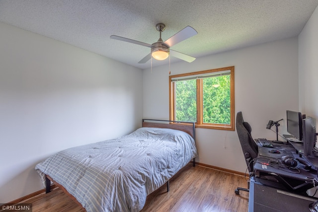 2226 Whispering Trl, Eagan, MN 55122 - bedroom with wood finished floors, baseboards, an office area, a textured ceiling, and ceiling fan