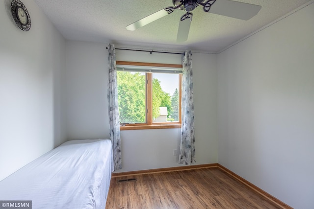 2226 Whispering Trl, Eagan, MN 55122 - unfurnished bedroom with wood finished floors, a ceiling fan, a textured ceiling, and baseboards