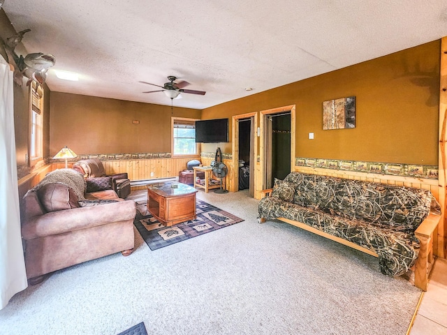 10547 Vermeil Dr NE, Deer River, MN 56636 - carpeted living room with a ceiling fan, a textured ceiling, a baseboard radiator, and a wainscoted wall