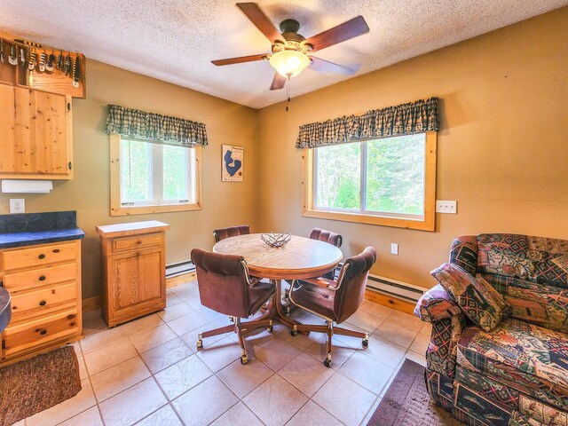10547 Vermeil Dr NE, Deer River, MN 56636 - dining room with healthy amount of natural light, baseboard heating, a textured ceiling, a ceiling fan, and light tile patterned flooring