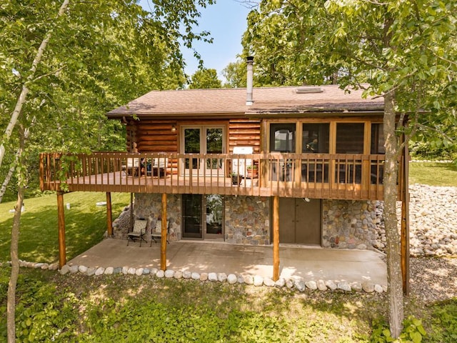 45517 County Road 346, Balsam Twp, MN 55709 - rear view of property featuring a patio, stone siding, a deck, a lawn, and a shingled roof