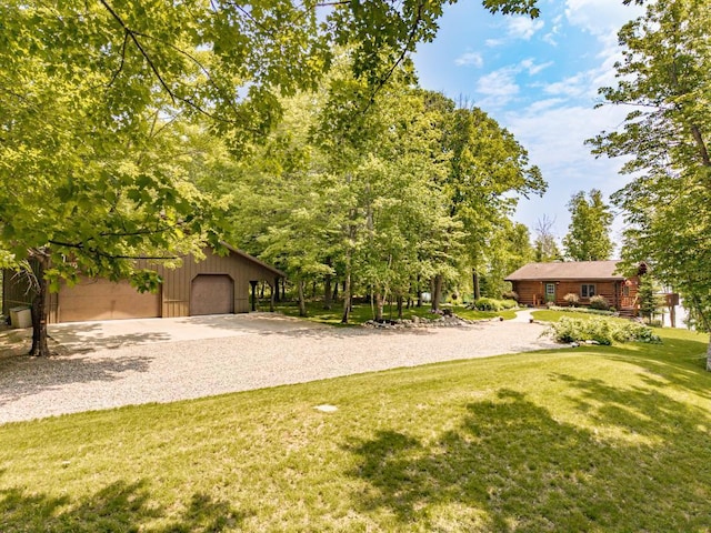 45517 County Road 346, Balsam Twp, MN 55709 - view of grassy yard featuring an outdoor structure, gravel driveway, and a detached garage