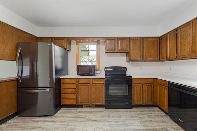 51343 20th Ave, Kenyon Twp, MN 55946 - kitchen with black appliances, brown cabinets, light countertops, and light wood finished floors