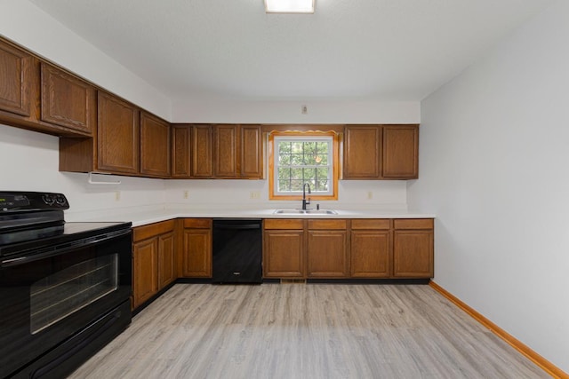 51343 20th Ave, Kenyon Twp, MN 55946 - kitchen featuring black appliances, light wood-style flooring, light countertops, and brown cabinets