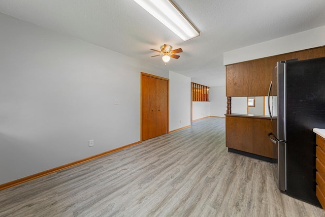 51343 20th Ave, Kenyon Twp, MN 55946 - kitchen with freestanding refrigerator, brown cabinets, light wood-style flooring, and a ceiling fan
