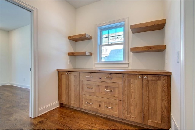 TBB403 College St, Northfield, MN 55057 - kitchen featuring open shelves, dark wood finished floors, brown cabinetry, and baseboards