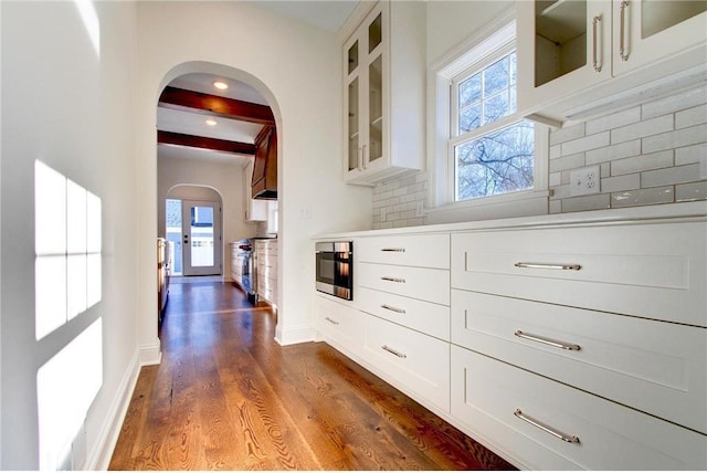 TBB403 College St, Northfield, MN 55057 - hall featuring arched walkways, dark wood-type flooring, healthy amount of natural light, beam ceiling, and baseboards