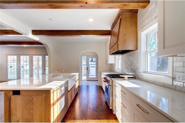 TBB403 College St, Northfield, MN 55057 - kitchen featuring beam ceiling, stainless steel range, a sink, arched walkways, and tasteful backsplash