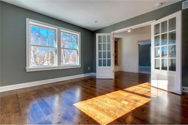 TBB403 College St, Northfield, MN 55057 - unfurnished room featuring a smoke detector, baseboards, wood finished floors, and french doors