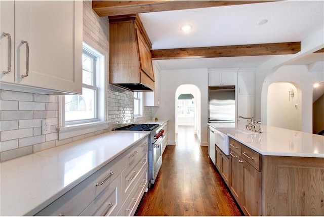 TBB403 College St, Northfield, MN 55057 - kitchen with stainless steel range, custom range hood, a sink, beam ceiling, and light countertops