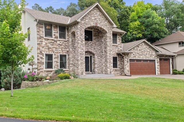11260 Hidden Oaks Ct N, Champlin, MN 55316 - view of front facade featuring stone siding, a garage, a front yard, asphalt driveway, and a shingled roof