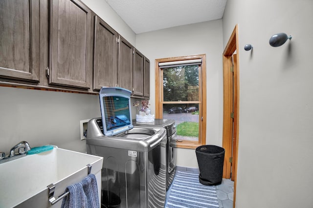 11260 Hidden Oaks Ct N, Champlin, MN 55316 - laundry room with cabinet space, separate washer and dryer, light tile patterned flooring, and a textured ceiling