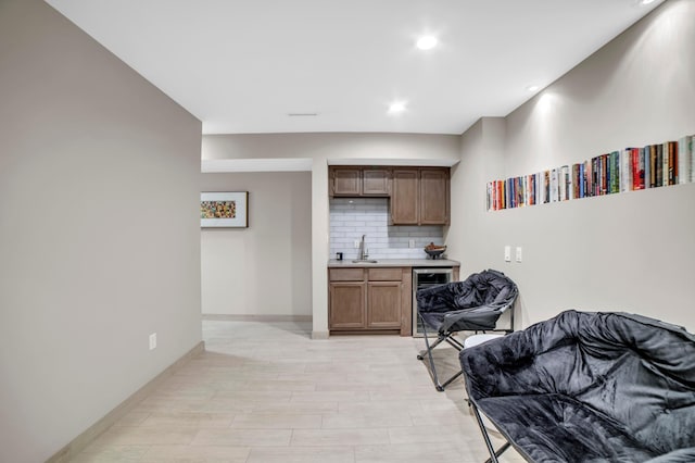 11260 Hidden Oaks Ct N, Champlin, MN 55316 - kitchen with wine cooler, a sink, decorative backsplash, baseboards, and light countertops