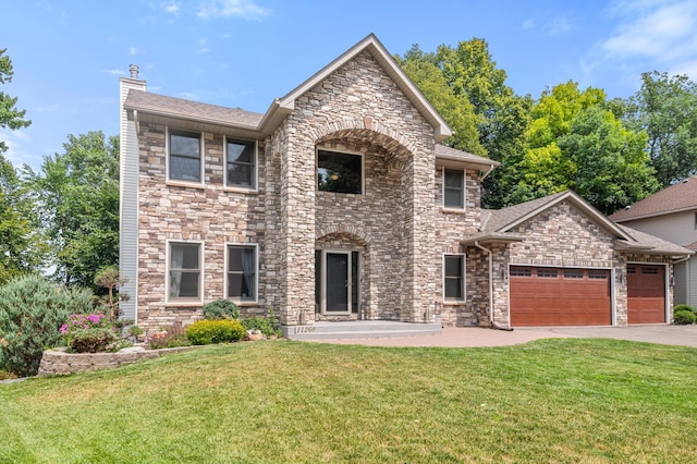 11260 Hidden Oaks Ct N, Champlin, MN 55316 - view of front facade featuring a garage, a front lawn, a chimney, stone siding, and driveway