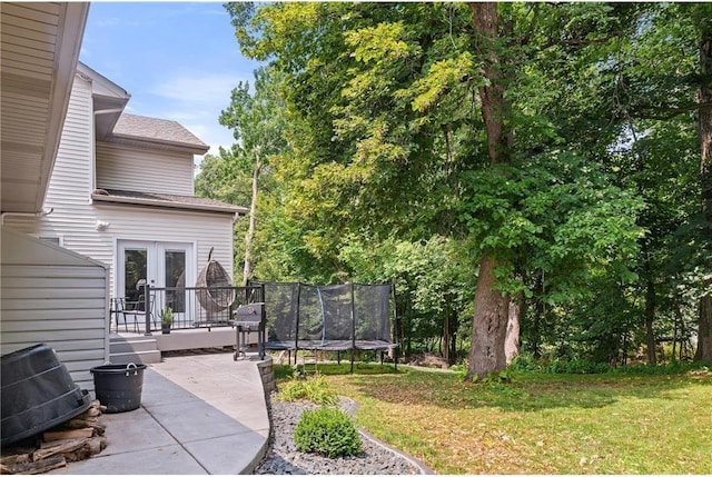 11260 Hidden Oaks Ct N, Champlin, MN 55316 - view of green lawn featuring french doors, a trampoline, and a patio