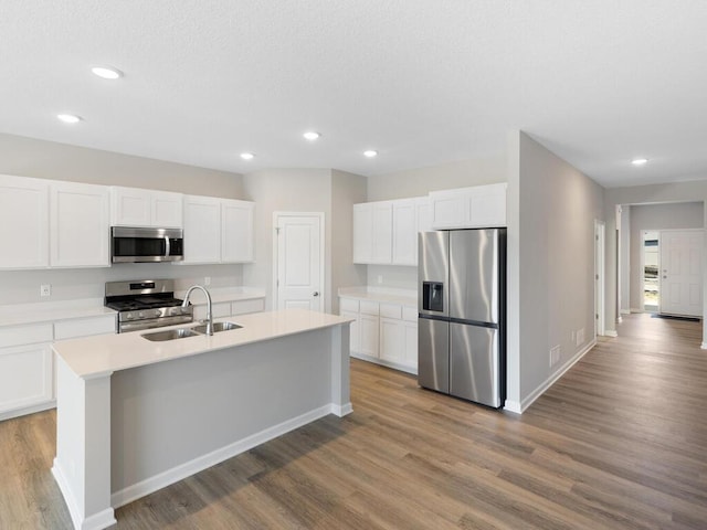 15981 Finale Ave N, Hugo, MN 55038 - kitchen featuring stainless steel appliances, a sink, wood finished floors, recessed lighting, and white cabinets