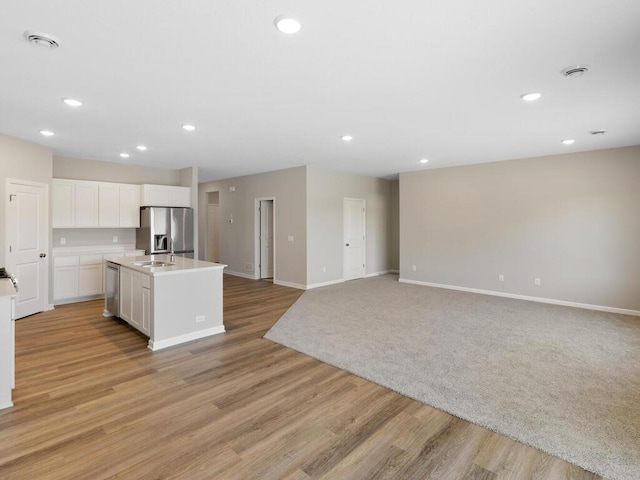 15981 Finale Ave N, Hugo, MN 55038 - kitchen with appliances with stainless steel finishes, baseboards, white cabinetry, light countertops, and a center island with sink