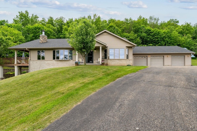 N1931 110th St, Union Twp, WI 54761 - ranch-style home with brick siding, a front lawn, a chimney, a garage, and asphalt driveway