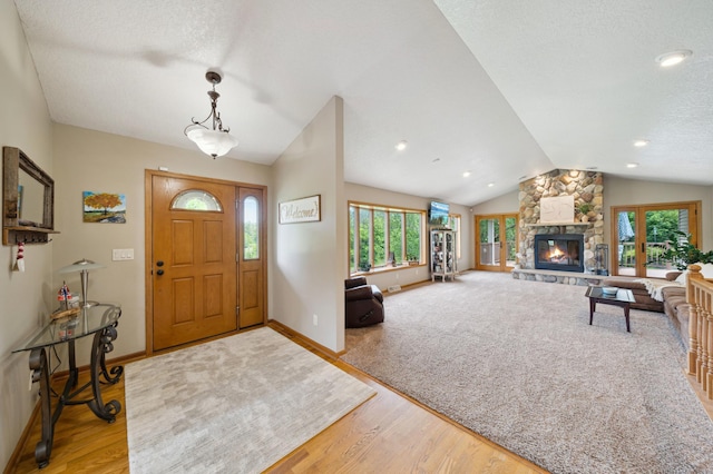 N1931 110th St, Union Twp, WI 54761 - foyer entrance featuring lofted ceiling, wood finished floors, baseboards, a fireplace, and a textured ceiling