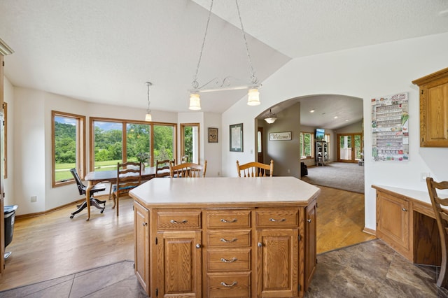 N1931 110th St, Union Twp, WI 54761 - kitchen with arched walkways, lofted ceiling, light countertops, a kitchen island, and hanging light fixtures