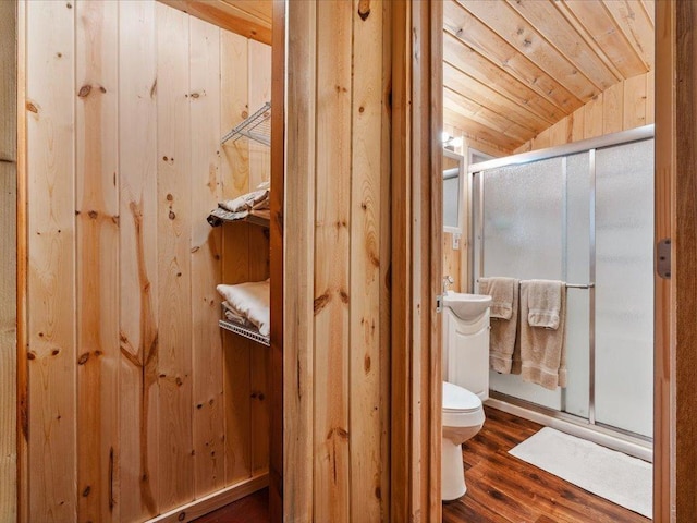 30202 Circle Dr, Breezy Point, MN 56472 - bathroom with toilet, a stall shower, lofted ceiling, wood finished floors, and wood walls