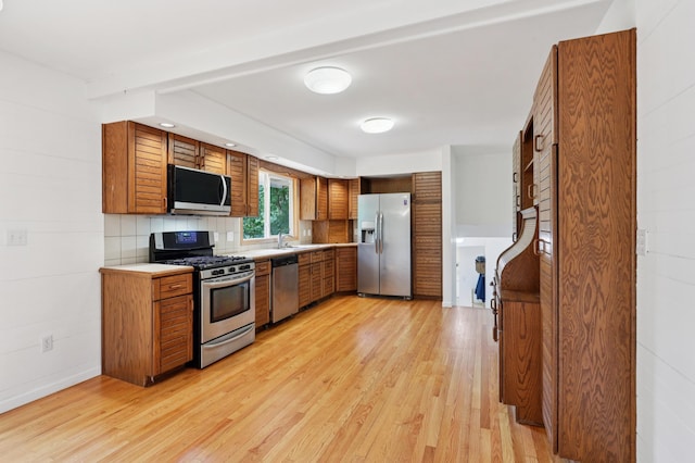 11600 Oberlin Rd, Minnetonka, MN 55305 - kitchen with stainless steel appliances, brown cabinetry, and light wood-type flooring