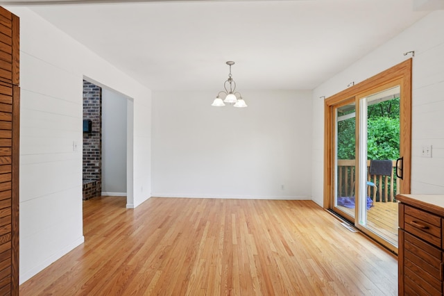 11600 Oberlin Rd, Minnetonka, MN 55305 - unfurnished room with light wood-style floors, a chandelier, and baseboards